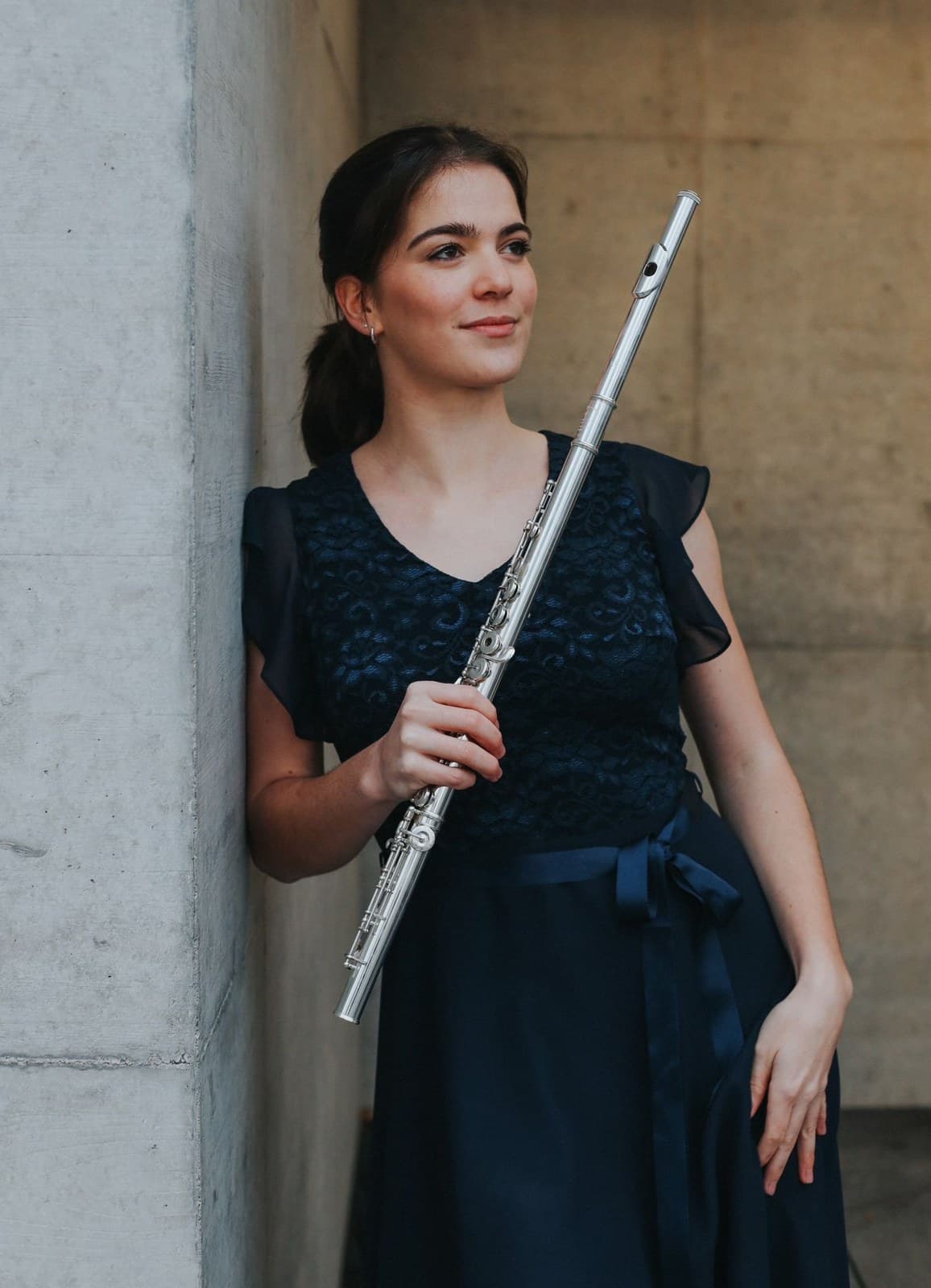 Deborah Schmid mit ihrer Querflöte an einer Betonwand